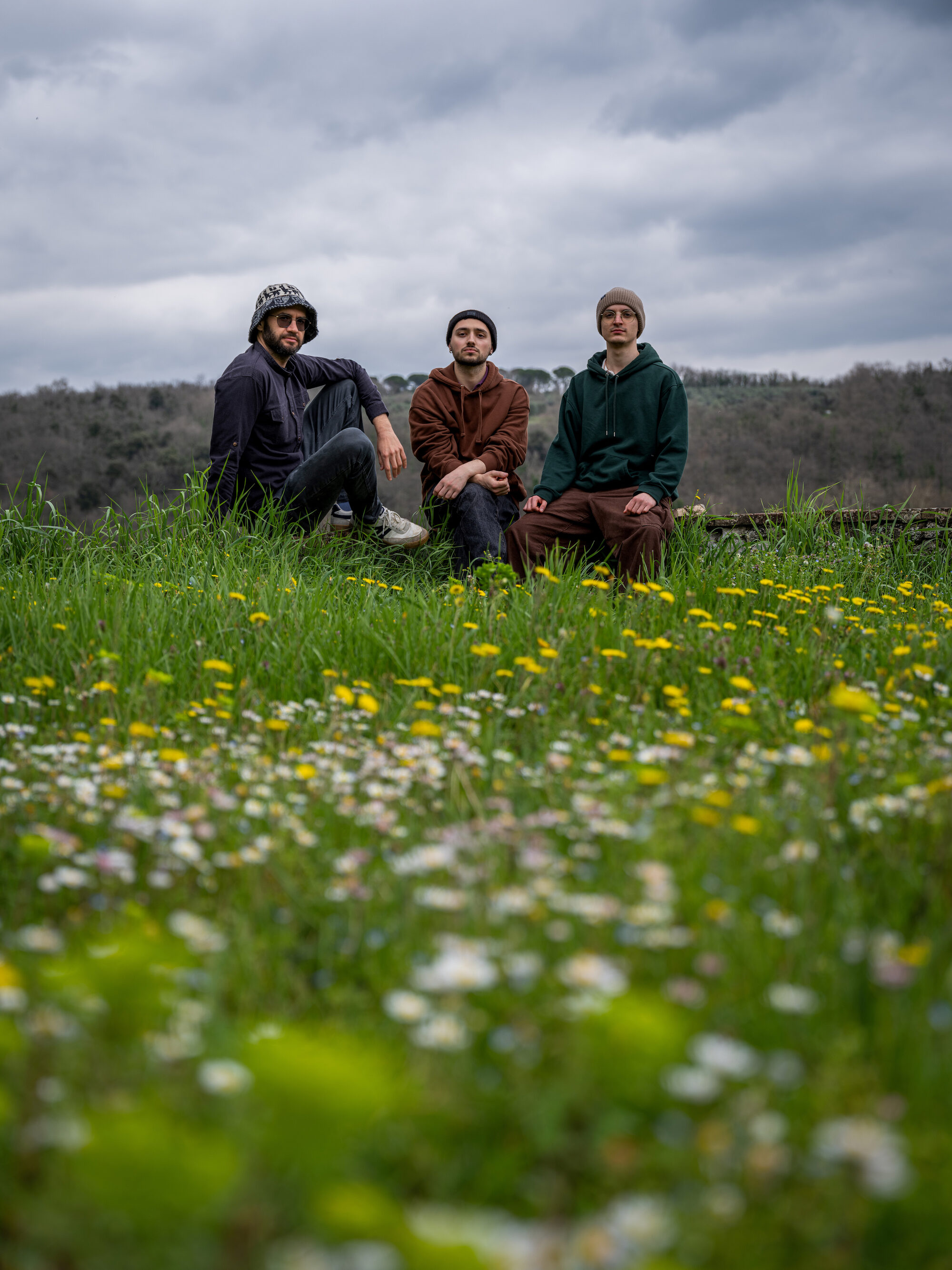Lost IQ — Francesco Faro, Giuseppe Vitale and Giuseppe Salime sitting in a field of wildflowers